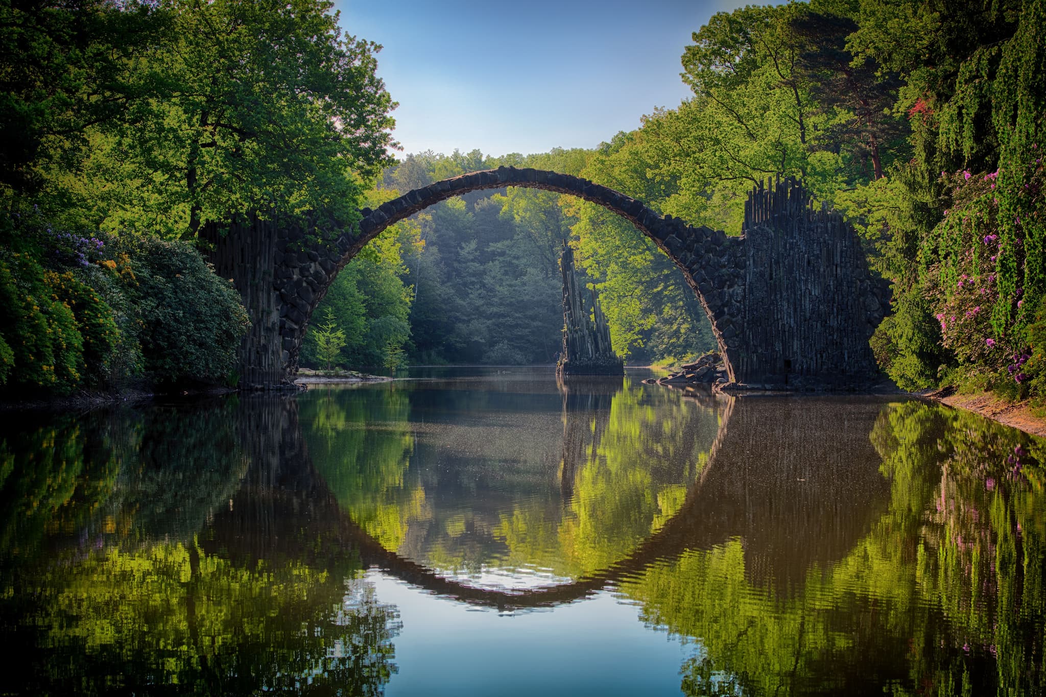 Stone arch bridge reflected in still water forming a perfect circle — hope and healing in Southern Oregon